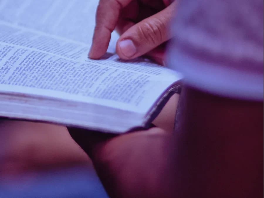 Read the Bible online: a hand following the text on an open page